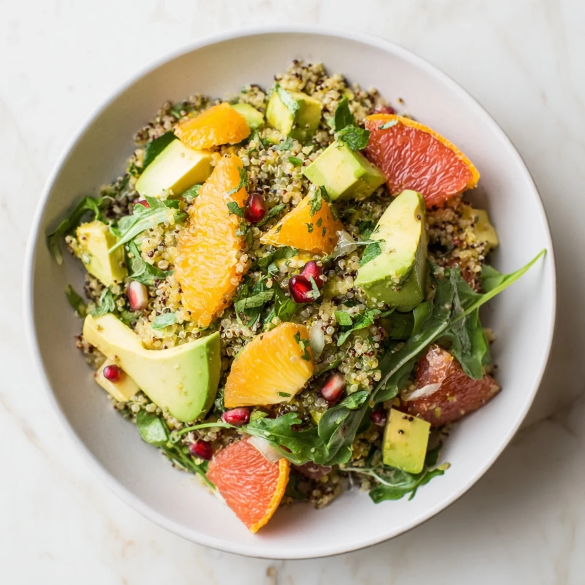 A colorful Fresh Citrus & Avocado Quinoa Bowl with glistening citrus and creamy avocado is ready to eat.