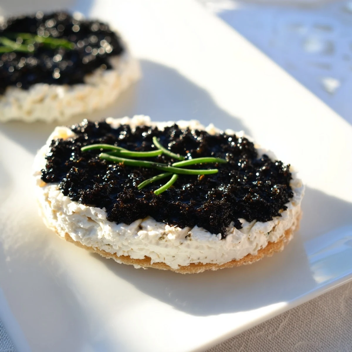 Elegant Victorian Cameo appetizer: smooth goat cheese canvases with dark, savory olive tapenade designs.