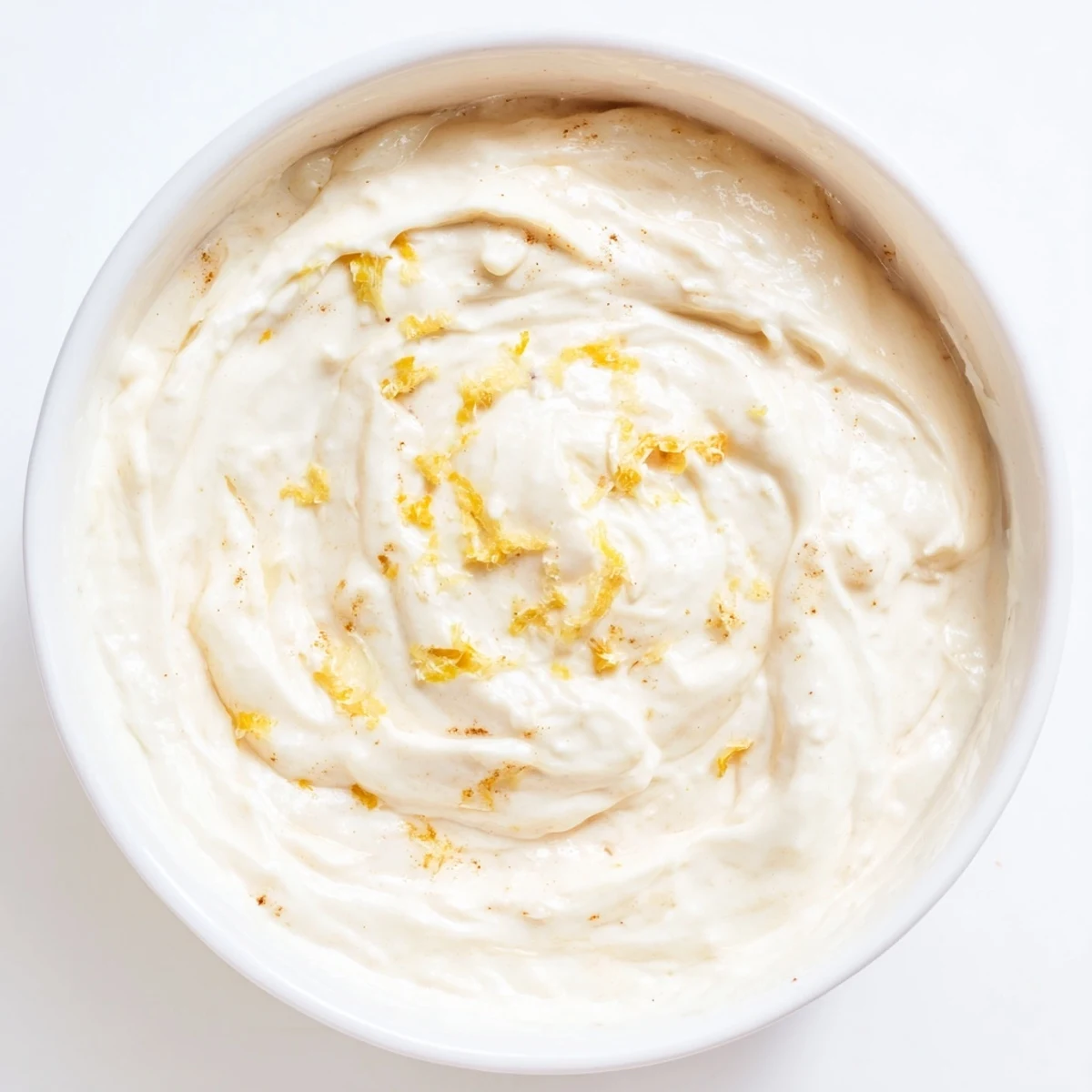 Creamy Greek Yogurt Fruit Dip, speckled with lemon zest, served alongside colorful fresh fruit.