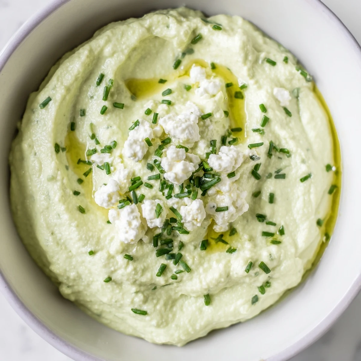 Creamy avocado cottage cheese dip, vibrant green and ready to be scooped with crunchy veggies.