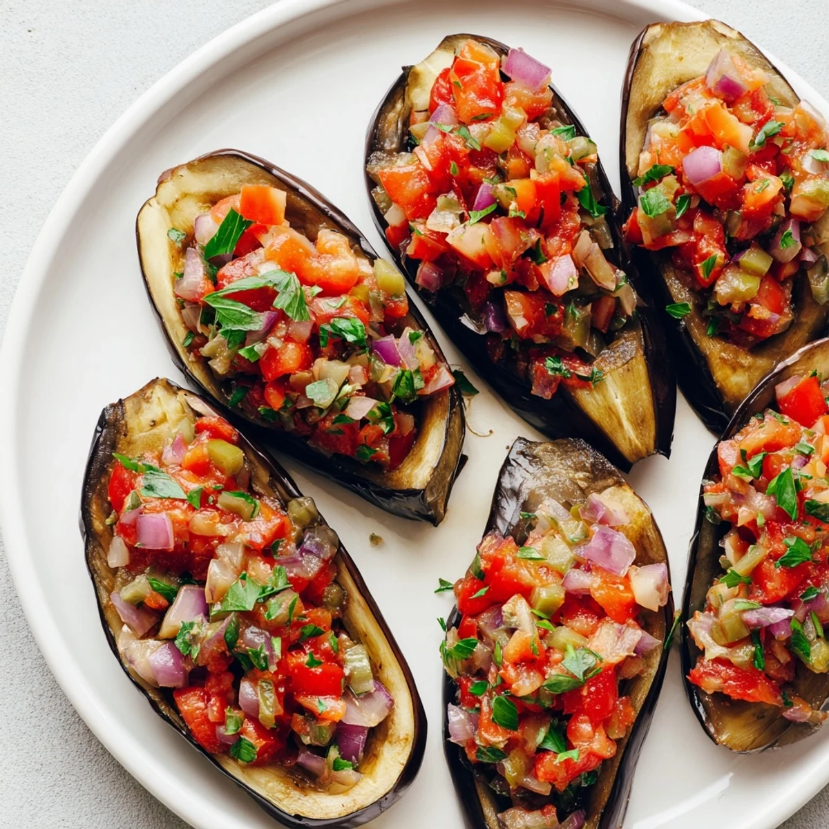 Golden, baked Imam Bayildi with tender eggplant halves, stuffed with a vibrant tomato filling.