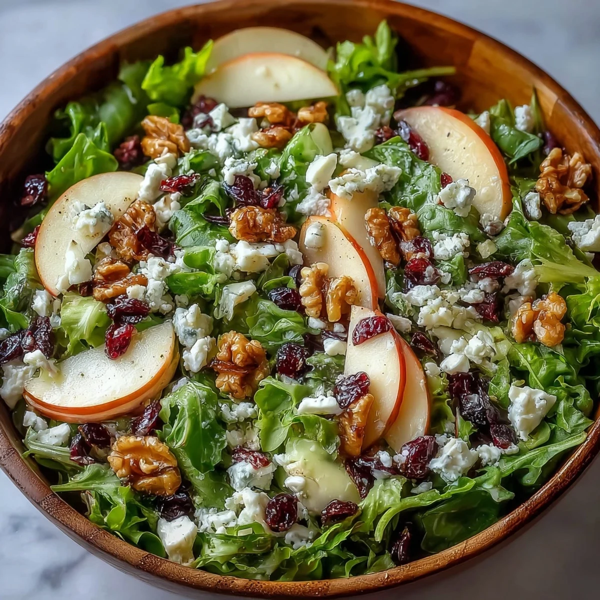 Freshly tossed Mixed Greens and Apple Salad featuring crisp greens, sweet apple slices, and crumbled cheese, ready for a healthy lunch or dinner side.