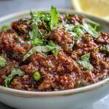 Steaming Venison Keema Curry served in a shallow bowl, with tender ground meat and aromatic spices, accompanied by warm naan bread for dipping.