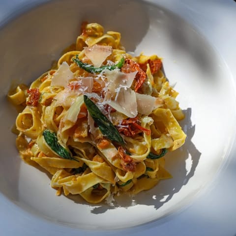 A close-up of One-Pot Creamy Tuscan Garlic Herb Pasta, showing a rich, garlic-infused sauce.