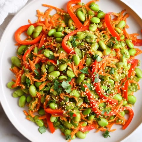 Close-up of a refreshing Asian Edamame Salad with sesame seeds, carrots, and a delicious homemade dressing.
