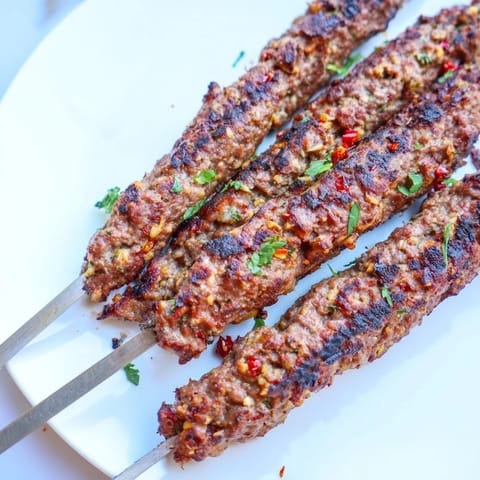 Perfectly charred Iraqi Kebab Tikka, served on flatbread with fresh herbs, ready to savor.