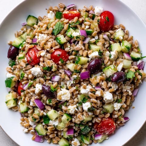 Hearty Farro Salad Mediterranean tossed with fresh herbs, cherry tomatoes, and cucumbers, ready to serve as a light lunch or refreshing side.