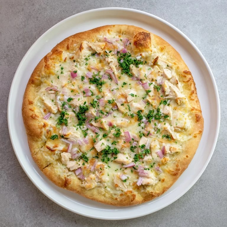 Whole Chicken Alfredo Pizza on a baking sheet with golden crust and bubbling cheese, ready to be served.
